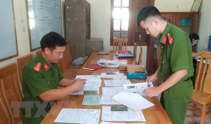 Cán bộ công an tỉnh Thái Bình thu thập hồ sơ, tài liệu trong một vụ án lừa đảo đi làm việc nước ngoài. (Ảnh: TTXVN phát)